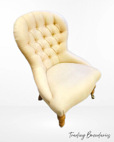 Button back bedroom chair on castors. Upholstered in cream suedette.